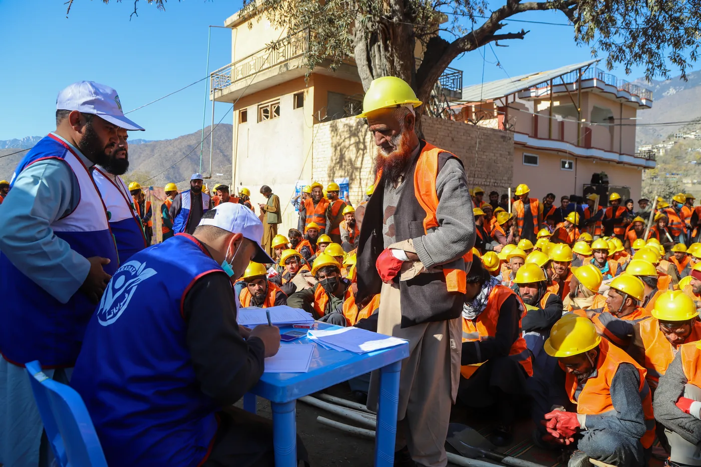 A worker meets FSCWEO staff at a cash-for-work registration table