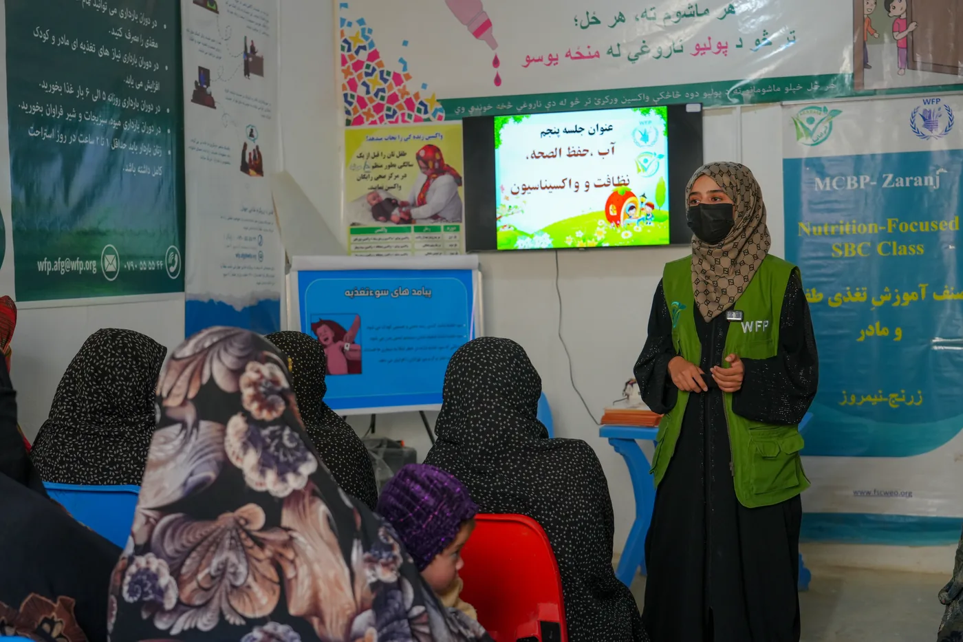 A facilitator explains nutrition information to women in a classroom
