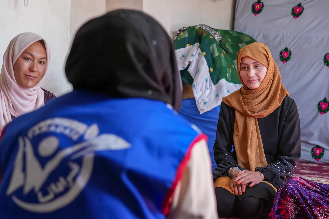 An FSCWEO staff member speaks with women during a field visit